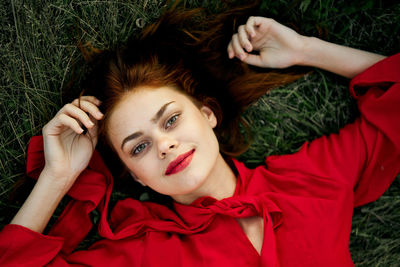 High angle view of young woman lying on grass