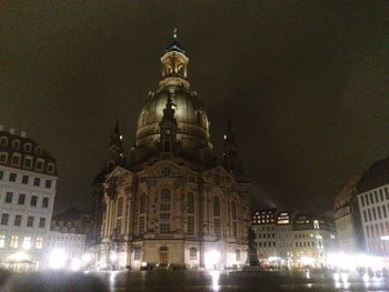 Illuminated buildings against sky at night