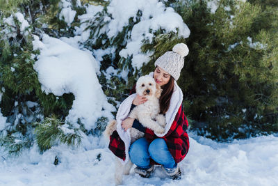 Rear view of girl sitting on snow during winter