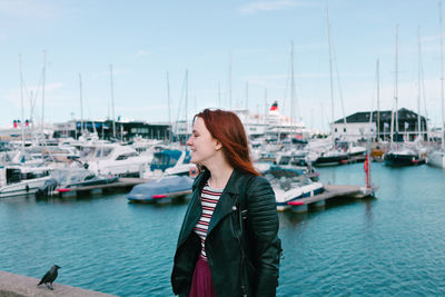 Woman looking at harbor against sky