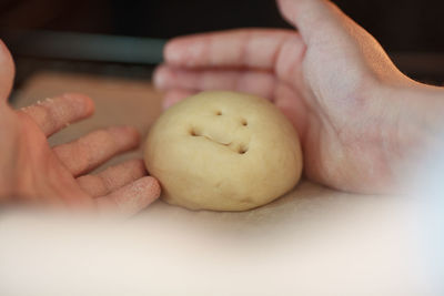 Close-up of hand kneading dough