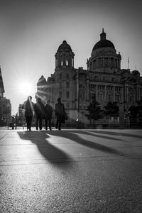 People walking on street against buildings in city