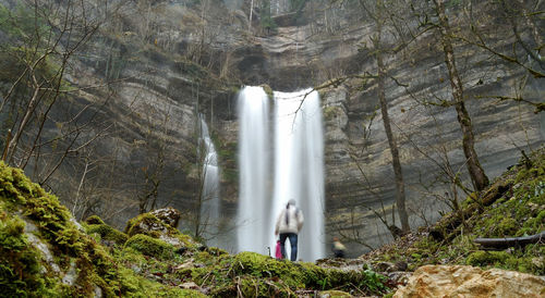 Low angle view of people against waterfall