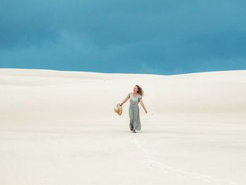 Woman wlakin in praia do saco, dunes, sergipe, brazil