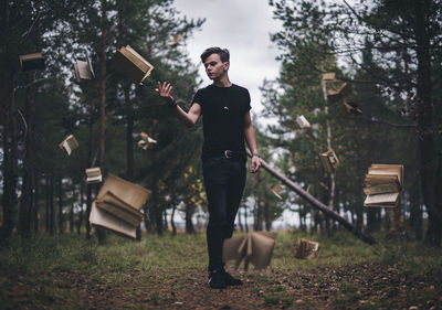 Full length of young man throwing books on field