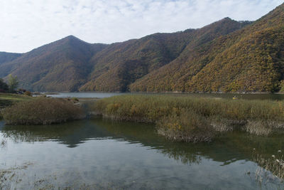 Scenic view of lake and mountains against sky