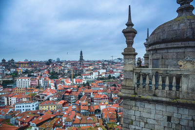 Buildings in city against cloudy sky