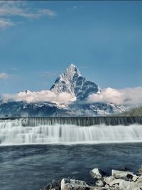 Scenic view of waterfall against sky