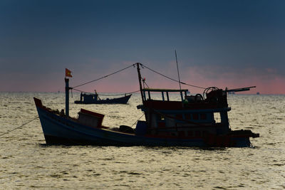 Ship moored on sea against sky during sunset