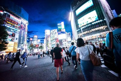 People walking on city street at night