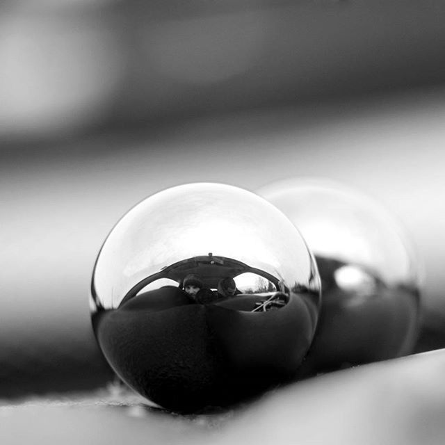 close-up, indoors, focus on foreground, reflection, selective focus, still life, sphere, transparent, glass - material, sunglasses, single object, table, circle, no people, day, home interior, glass, metal, shiny, ball