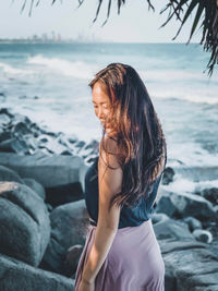 Young woman on rock at beach