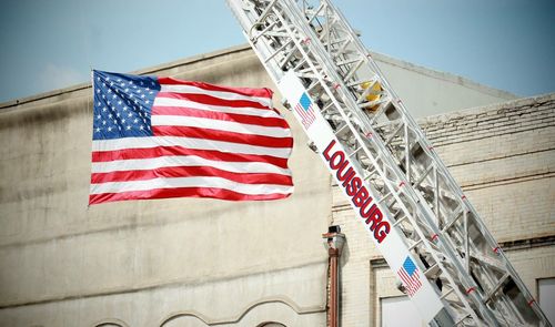 Low angle view of american flag against sky