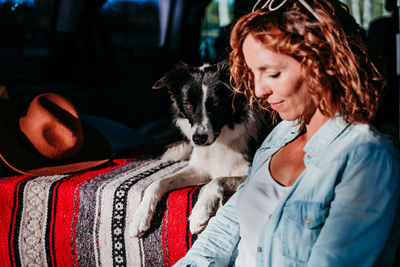 Close-up of woman with dog sitting in camper trailer