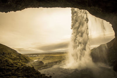 Scenic view of waterfall against sky