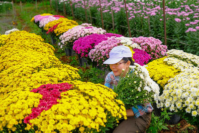 Woman standing by multi colored flowering plants