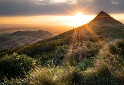 Sun setting down behind an unusually shaped mountain,port hills area, christchurch, new zealand