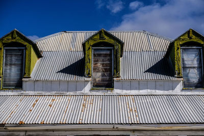 View of three windows on a rooftop against sky