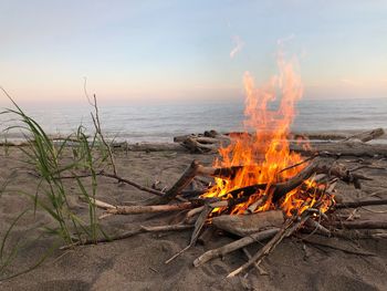 Panoramic view of bonfire on beach against sky