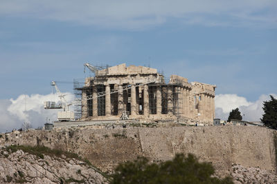 Parthenon with crane and scaffolding against sky