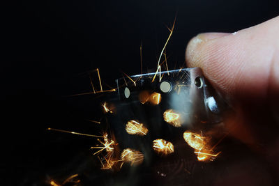 Cropped hand of person igniting cigarette lighter