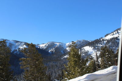 Scenic view of snowcapped mountains against clear blue sky