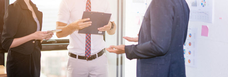 Midsection of business people discussing in office