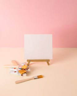 Paint brushes, paint tubes and canvas on pastel background. minimal concept. copy space