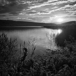 Scenic view of lake against sky at sunset