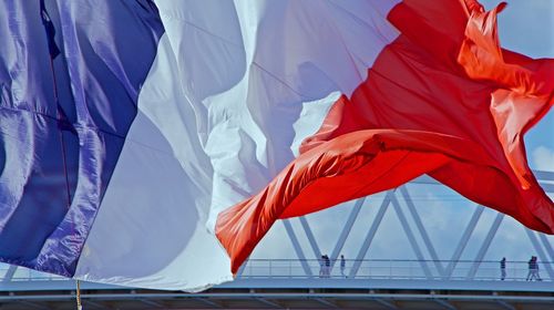 Low angle view of flag against blue sky