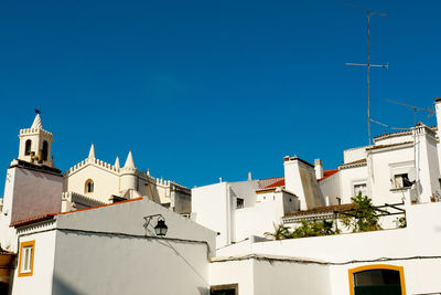 Low angle view of buildings against clear blue sky