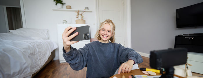 Young woman using digital tablet while sitting at home