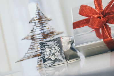 Gift boxes near christmas tree inside home. box with holiday ribbon with bows. warm festive 