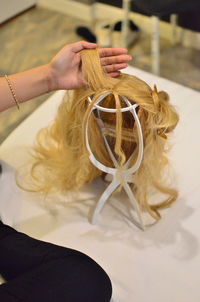 Midsection of woman touching wig