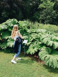 Full length of woman standing by tree