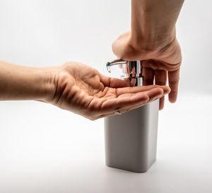 Midsection of people holding hands over white background