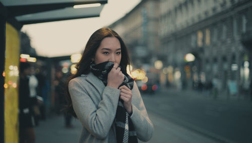 Portrait of beautiful woman standing in city