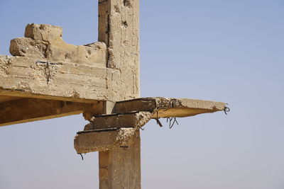 Low angle view of old cross against clear sky