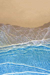 Sea waves rushing towards shore against sky