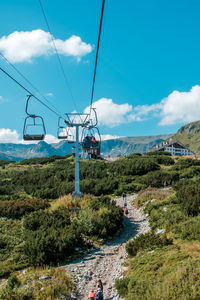 Low angle view of overhead cable car against sky