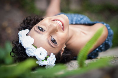 Portrait of young woman lying outdoors