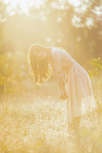 Side view of woman standing on field