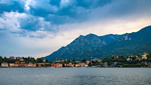 Scenic view of townscape by mountains against sky