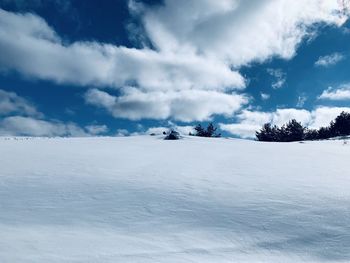 Snow covered landscape against sky