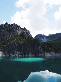 Scenic view of lake by mountains against sky