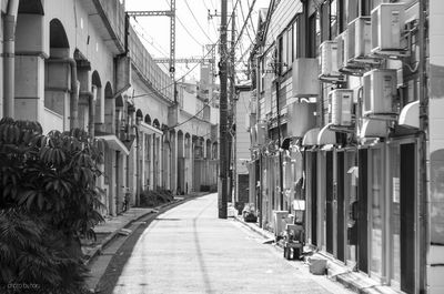 Empty road amidst buildings in city