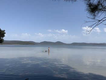 Scenic view of people in sea against sky