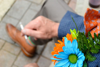 Close-up of man with boutonniere holding cigarette