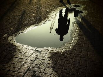Reflection of silhouette person on puddle