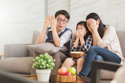 Young woman sitting on sofa at home